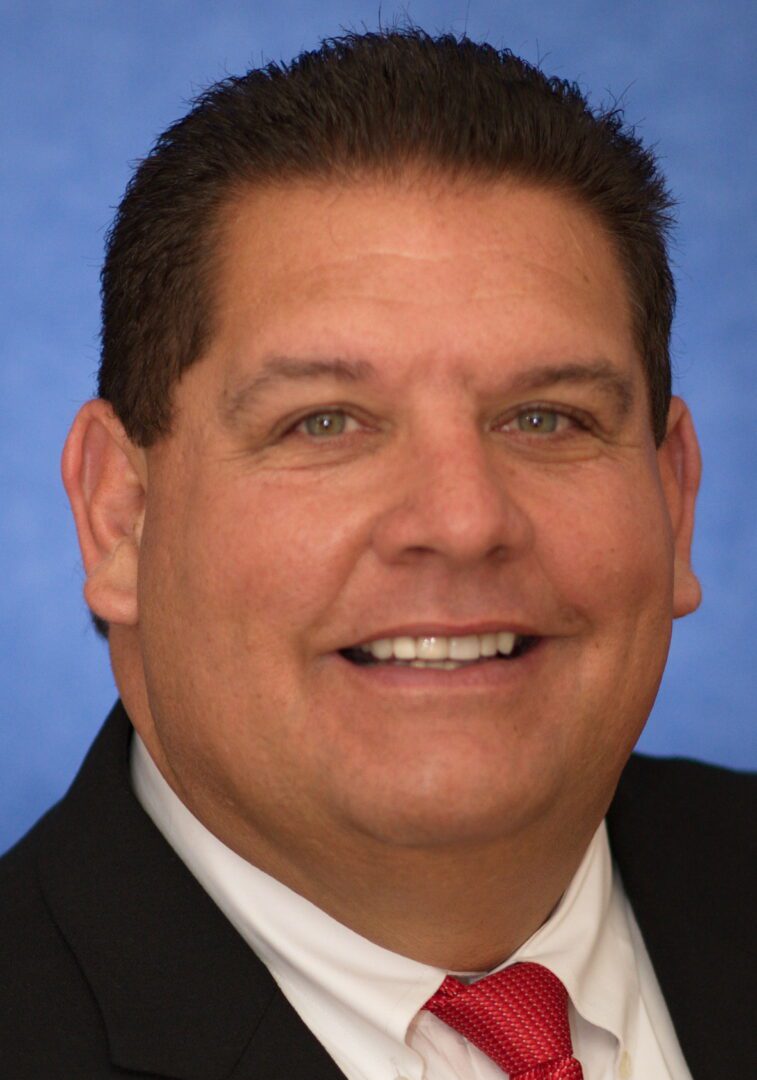 A smiling man wearing a suit